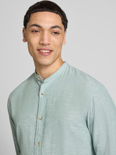 Männermodel trägt Regular Fit Freizeithemd aus Baumwoll-Leinen-Mix von Jack & Jones, Stehkragen, Knopfleiste, Nahaufnahme Oberkörper.