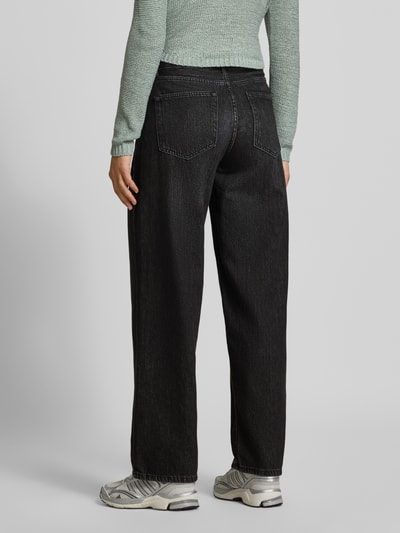 Vrouwenmodel draagt zwarte loose fit jeans uit katoendenim, lichte wassing, zichtbaar stiksel, Loose Fit Jeans aus reiner Baumwolle Modell 'TOLEDO' van ONLY, dames Wide & Loose Fit jeans, volledige lichaamsweergave achteraan.