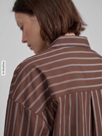 Kobieta nosi bluzkę koszulową Regular Fit Hemdbluse mit Baumwoll-Anteil model 'OREGON' od ONLY, brązowe paski, damska bluzka koszulowa, zbliżenie na plecy, KI-modifiziertes Bild