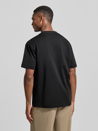 Männermodel trägt Relaxed Fit T-Shirt aus reiner Baumwolle von Marc O'Polo in Schwarz, unifarben, Feinripp, Ganzkörperansicht Rückansicht.