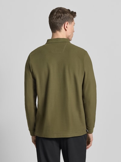 Männermodel trägt Poloshirt mit Label-Stitching von Fynch-Hatton, reine Baumwolle, Regular-Fit in Oliv, Rückenlänge 37 cm, Ganzkörperansicht Rückansicht.