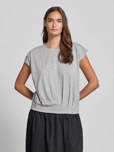 Frauenmodel trägt T-Shirt mit Rundhalsausschnitt und Kappärmeln von Christian Berg Woman im Material-Mix, Regular-Fit, Drapierungen, Rückenlänge 54 cm, Ganzkörperansicht von vorne.