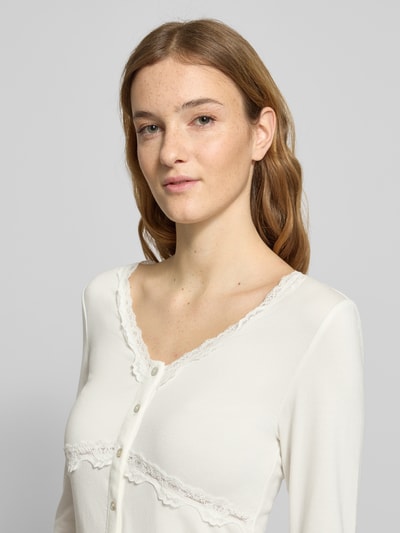 Frauenmodel trägt Slim Fit Langarmshirt aus Viskose-Mix Modell 'SINI' von Only, unifarben, V-Ausschnitt, Nahaufnahme Oberkörper.