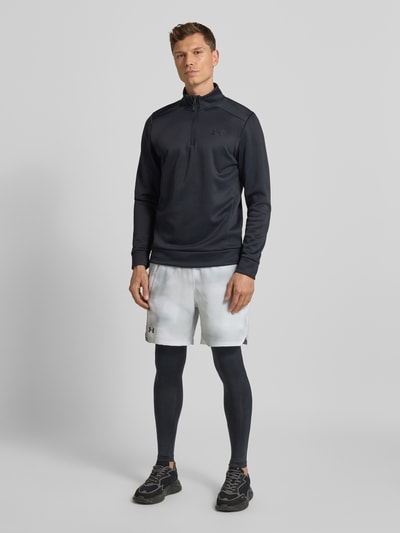 Męski model nosi Leggings mit elastischem Bund und Logo von Under Armour, dopasowany materiał ze stretch, czarne, widok całej sylwetki z przodu.