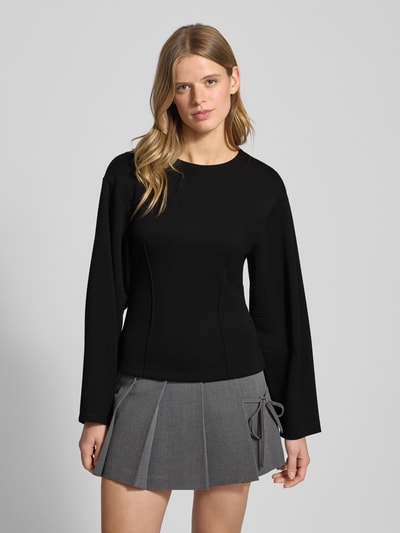 Frauenmodel trägt Shaped Fit Langarmshirt mit Viskose-Anteil Modell 'TOC' von Only, unifarben schwarz, Kimonoärmel, Nahaufnahme Oberkörper.