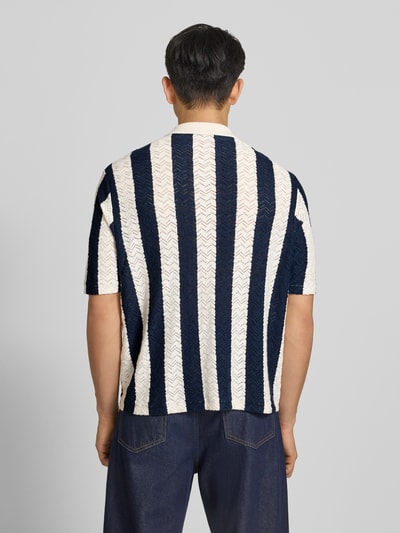 Männermodel trägt Regular Fit Poloshirt mit Knopfleiste Modell 'TYLER' van Jack & Jones, katoenmix, donkerblauw-wit gestreept, halve mouw, rugaanzicht, Ganzkörperansicht Rückansicht.