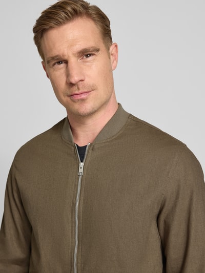 Männermodel trägt Jacke aus Baumwoll-Leinen-Mix mit Zweiwege-Reißverschluss von Jack & Jones Premium in Regular-Fit, Stehkragen, Nahaufnahme Oberkörper, Material in Braun, sichtbare glatte Textur, Kontext: Herren Jacke, Rückenlänge 68 cm, Schulterbreite 45 cm, Brustweite 54 cm, Ärmellänge 66 cm, Größe M.