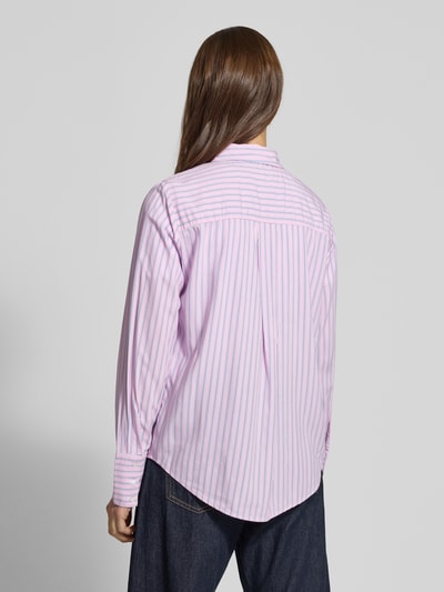 Vrouwenmodel draagt Regular Fit Hemdbluse aus reiner Viskose Modell 'BERIT' van Only met allover gestreept patroon in roze en wit, afgeronde zoom, lange mouw met brede manchet, materiaal viscose, achteraanzicht volledige lichaamsopname.