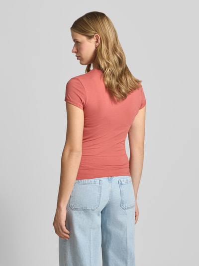 Frauenmodel trägt T-Shirt mit Motiv-Stitching und Rundhalsausschnitt von REVIEW, mieszanka bawełny i elastanu, krój slim fit, długość tyłu 54 cm, jasnoróżowa kolorystyka, gładka faktura, Ganzkörperansicht Rückansicht.