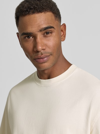 Männermodel trägt Boxy Fit T-Shirt aus reiner Baumwolle Modell 'CORY' von Selected Homme in Creme, glatte Textur, Nahaufnahme Oberkörper, Herren T-Shirt von Selected Homme