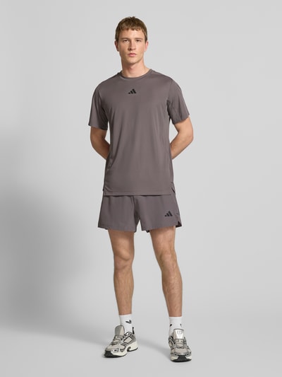 Mannenmodel draagt Regular Fit T-shirt met Logoprint model 'Power' van adidas Training in grijs, ronde hals, ruglengte bij maat M 65 cm, ganzekorpsvooraanzicht.