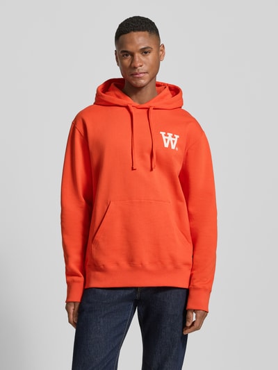 Mannelijk model draagt Hoodie met Logo-Print en Känguru-Tasche van Wood Wood, los vallende fit, katoen, logo, kangoeroezak, voorkant, borst detail, volledige lichaamsaanzicht van voren