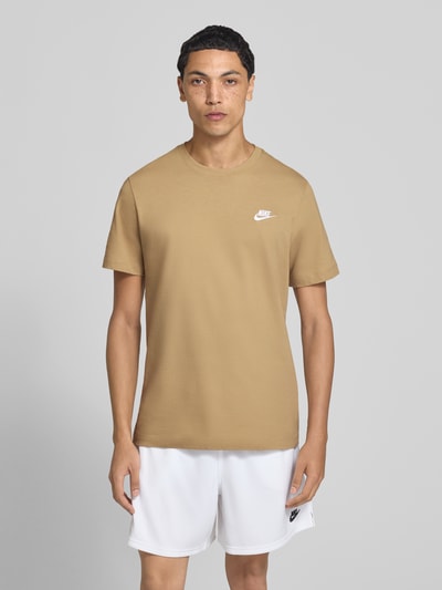 Männermodel trägt Regular Fit T-Shirt aus reiner Baumwolle von Nike in Beige zu weißen Shorts, Ganzkörperansicht von vorne. Herren T-Shirt von Nike.