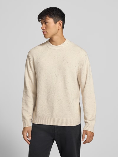 Männermodel trägt Regular Fit Strickpullover mit Rundhalsausschnitt von JACK & JONES, beige, Baumwoll-Mix, Logo-Patch, Ganzkörperansicht von vorne.