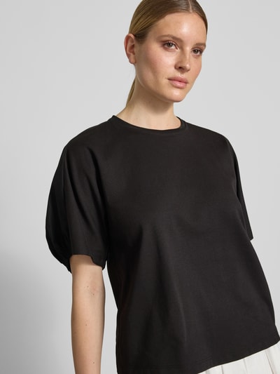 Modelka kobieca ma na sobie T-Shirt z okrągłym dekoltem CELLULA od MM by Max Mara, czarna bawełna, krój relaxed fit, widok z przodu, zbliżenie na górną część ciała.