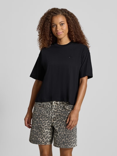 Frauenmodel trägt Regular Fit T-Shirt aus reiner Baumwolle Modell 'CHESTER' von Carhartt Work In Progress in Schwarz, Ganzkörperansicht von vorne. Damen T-Shirt, Stehkragen, Halbarm, Rückenlänge bei Größe S 56 cm.