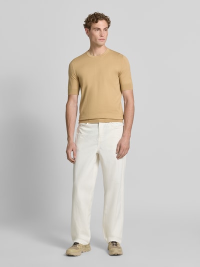 Męski model nosi beżowy Slim Fit T-Shirt aus Feinstrick Modell 'SAN CARL-CV' od HUGO, gładka faktura, jasne kolory, Ganzkörperansicht z przodu.