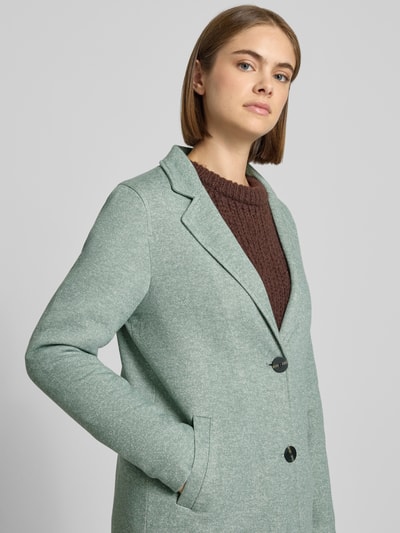 Frauenmodel trägt Regular Fit Mantel mit Baumwoll-Anteil Modell 'SEDONA' von ONLY in Hellgrün, glatte Textur, Damen Mantel, Nahaufnahme Oberkörper.
