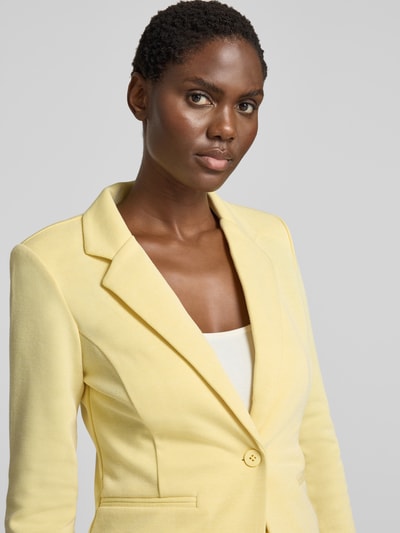 Kobiece modelka nosi Slim Fit Blazer mit Paspeltaschen Modell 'KATE PIQUE' von ICHI, Mieszanka bawełny, kołnierz z połami, zapięcie na guzik, kieszenie z wypustkami, Długość tyłu w rozmiarze S: 56 cm, Szerokość w rozmiarze S: 36 cm, Długość rękawów w rozmiarze S: 60 cm, jasny żółty kolor, gładka faktura, Nahaufnahme górnej części ciała.