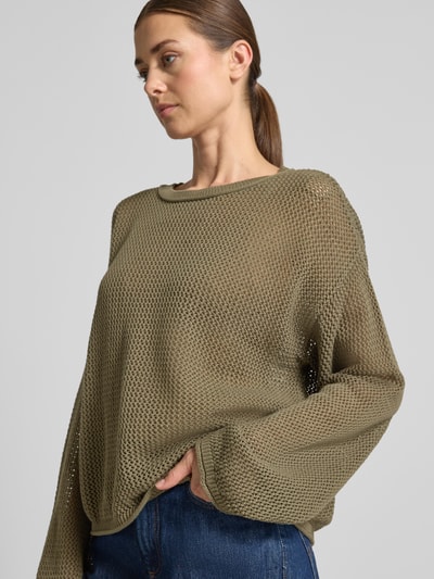 Frauenmodel trägt Loose Fit Pullover aus reiner Baumwolle Modell 'C_FARDE' von BOSS Orange in Oliv mit grobmaschiger Struktur, Nahaufnahme Oberkörper.
