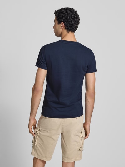 Männermodel trägt Regular Fit T-Shirt mit Logo-Stitching von Superdry in Dunkelblau, Baumwolle, mit Rundhalsausschnitt, Ganzkörperansicht Rückansicht