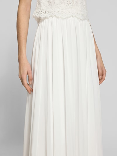 Kobieta nosi Maxirock aus Chiffon mit Reißverschluss od Luxuar, biały zwiewny materiał, fason A-linia, Szerokość w rozmiarze 36: 34 cm, Długość całkowita: 125 cm, zbliżenie na górną część spódnicy.