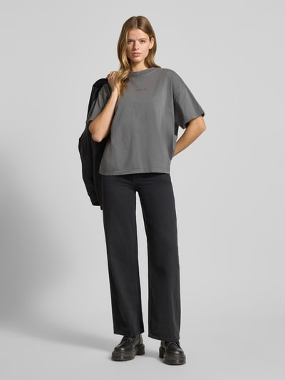 Kobiece modelka nosi Oversized T-Shirt mit Label-Stitching od Pegador, damski t-shirt z bawełny, krój oversized, prążkowany okrągły dekolt, wyhaftowane logo, długość tyłu 60 cm w rozmiarze S, widok całej sylwetki z przodu.