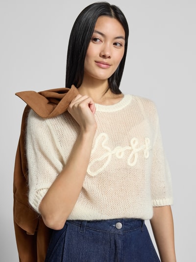 Frauenmodel trägt Regular Fit Pullover aus Schurwoll-Modal-Mix Modell 'C_Farezza' von BOSS Orange in Creme mit strukturierter Oberfläche, Nahaufnahme Oberkörper.