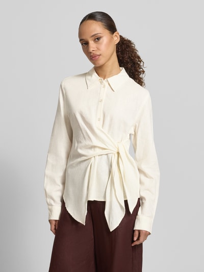 Frauenmodel trägt Bluse aus Leinen-Viskose-Mix mit Knoten-Detail von GUIDO MARIA KRETSCHMER WOMAN, lange Ärmel, taillierter Schnitt, Hemdblusenkragen, Knopfleiste, Farbe Creme, Modell 'MATHILDA', Rückenlänge 58 cm, Ärmellänge 64 cm, Ganzkörperansicht von vorne.