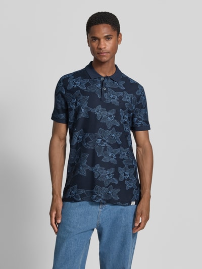 Männermodel trägt Slim Fit Poloshirt mit floralem Allover-Print von Lerros in Dunkelblau, Reine Baumwolle, Polokragen, Kurzärmelig, Ganzkörperansicht von vorne. Rückenlänge bei Größe M: 72 cm.