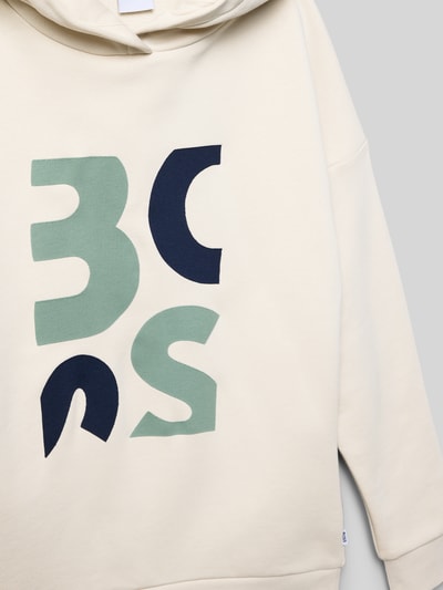Mädchen trägt Regular Fit Hoodie aus Baumwoll-Mix von BOSS, Optik: Unifarben, Label-Print, Kapuze, Langarm, Ganzkörperansicht von vorne.