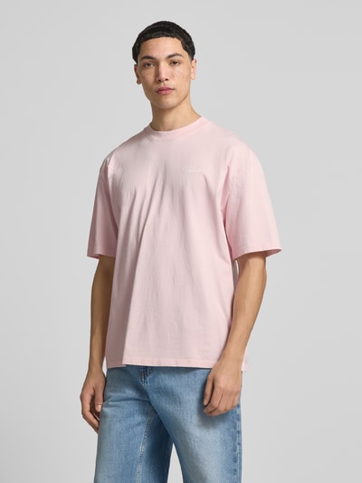 Męski model nosi Oversized T-Shirt aus reiner Baumwolle Modell 'Pike' von Pegador, różowy kolor, krój oversize, widok z przodu całej sylwetki.