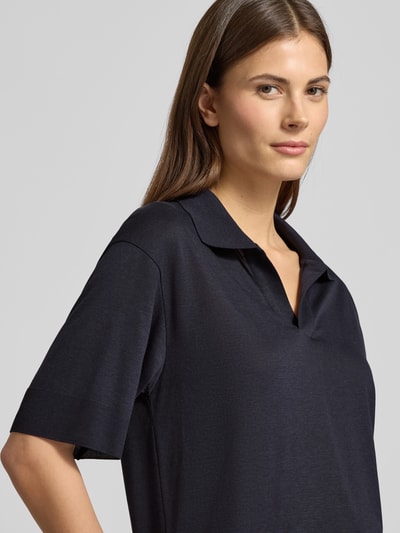 Vrouwenmodel draagt T-Shirt met Polokragen van Windsor in donkerblauw, lyocell-katoenmix, losse fit, V-hals, geribde boorden, labeldetail, halve lichaamsclose-up vooraan.