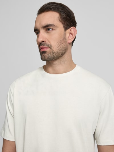 Männermodel trägt Oversized T-Shirt mit Rundhalsausschnitt von Lindbergh, pure katoen, labeldetail, licht crème, nahaufnahme oberkörper