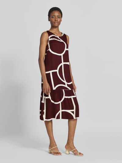 Vrouwenmodel draagt Ausgestelltes Freizeitkleid aus reiner Viskose model 'Wicy atelier' van OPUS Dames, donkerrood met witte geometrische vormen, vrijetijdsjurk, volledige lichaamsaanzicht van voren.