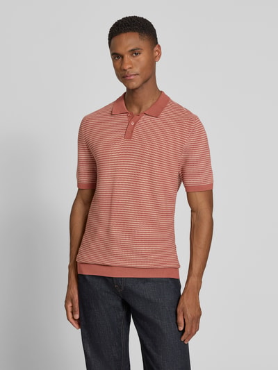 Männermodel trägt Slim Fit Strick-Poloshirt in Two-Tone-Machart Modell 'Triton' von Drykorn, dezente Rot- und Cremetöne, Nahaufnahme Oberkörper, reine Baumwolle, Strukturstrick, Herren Poloshirt