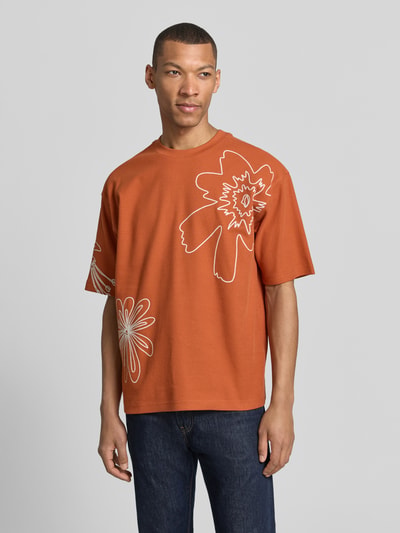 Männermodel trägt T-Shirt mit Motiv-Stitching von JAKE*S STUDIO MEN, Baumwoll-Mix mit Stretch-Anteil, Regular-Fit, Rundhalsausschnitt, orange, weiße Kontur-Blumen, Rückenlänge bei Größe M: 69 cm, Ganzkörperansicht von vorne.