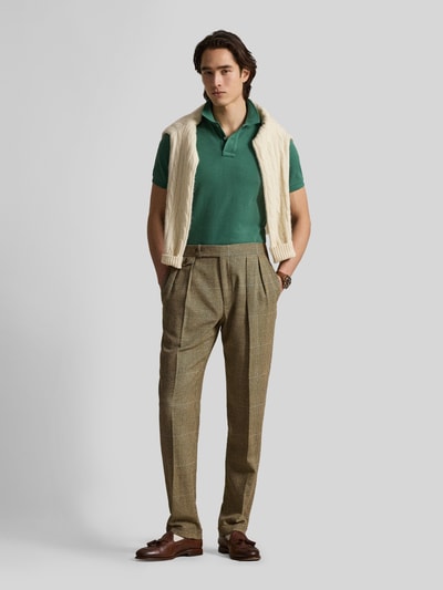 Männermodel trägt Regular Fit Poloshirt aus reiner Baumwolle von Polo Ralph Lauren in Grün, unifarben, Piqué-Struktur, Logo-Detail, Ganzkörperansicht von vorne.