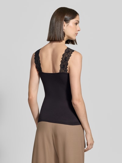 Frauenmodel trägt Slim Fit Tanktop aus Viskose-Mix Modell 'ROSA' von VERO MODA in Schwarz mit Spitzen-Trägern, Ganzkörperansicht Rückansicht. Damen Tanktop von VERO MODA.