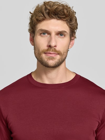 Männermodel trägt Regular Fit Longsleeve aus reiner Baumwolle Modell 'Pima' von RAGMAN in Bordeaux, glatte Textur, Nahaufnahme Oberkörper. Rückenlänge bei Größe M: 69 cm, Rundhalsausschnitt.