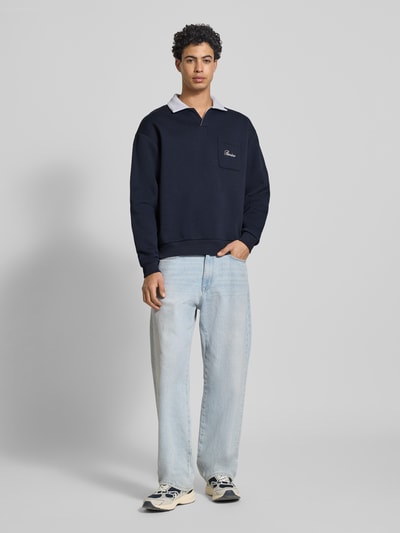 Männermodel trägt Sweatshirt mit Kontrastkragen und borstzak met geborduurd logo van Review, materiaalmix met katoen, regular fit, ganzkörperansicht von vorne