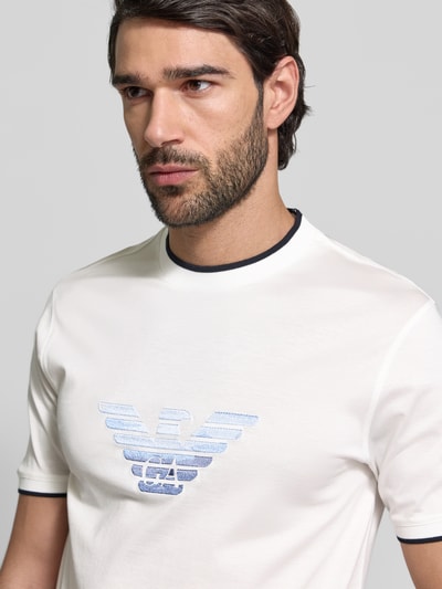 Männermodel trägt Regular Fit T-Shirt mit Logo-Stitching von Emporio Armani, Lyocell-Mix, weiß mit Rundhalsausschnitt, Nahaufnahme Oberkörper
