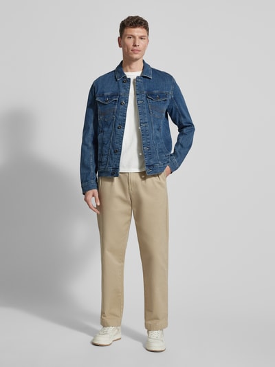 Männermodel trägt Regular Fit Jeansjacke aus Baumwoll-Mix von Tom Tailor in Blau mit Umlegekragen und Knopfleiste, Ganzkörperansicht von vorne.