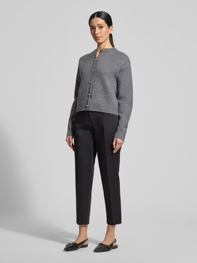 Modelka kobieca nosi Straight Fit Stoffhose mit Lyocell-Anteil Modell 'Mara' od Brax, antracytowy kolor, tkanina bawełniano-lyocellowa, prasowane kanty, skrócony fason, kieszenie boczne i tylne, zapięcie na guzik i zamek, szerokość w rozmiarze 36: 39 cm, długość nogawki wewnętrznej w rozmiarze 36: 68 cm, widok całej sylwetki z przodu