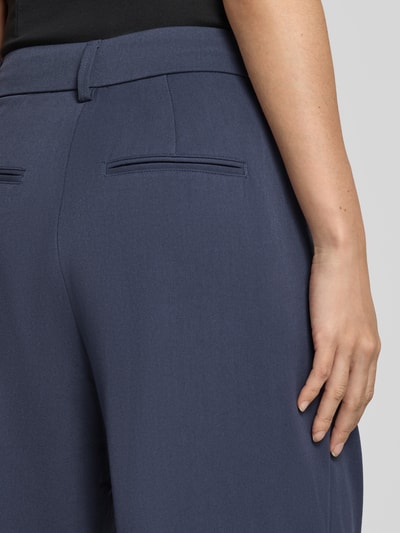 Frauenmodel trägt High Waist Bundfaltenhose mit Bügelfalten Modell 'Henrika' von MSCH COPENHAGEN aus Viskosemix, unifarben, Detailaufnahme Rückansicht.