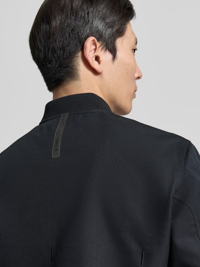 Männermodel trägt Jacke mit Stehkragen und Zweiwege-Reißverschluss Modell 'FLAP' von G-LAB aus Baumwoll-Mix, Regular-Fit, Detailaufnahme Rückansicht.