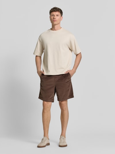 Männermodel trägt Regular Fit Sweatshorts aus Baumwoll-Mix Modell 'JACE' von SELECTED HOMME in Braun mit Cordstruktur, unifarben, Ganzkörperansicht von vorne.