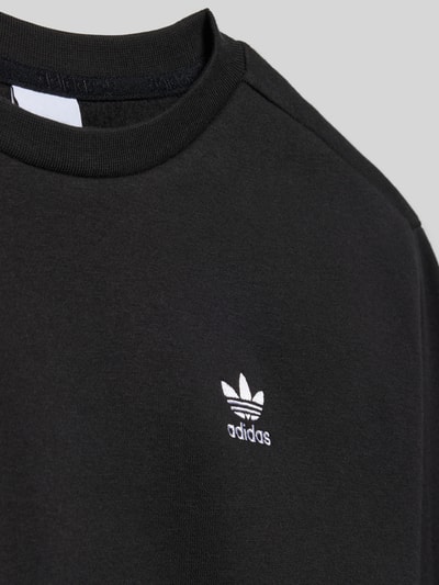 Produktfoto, Sweatshirt mit Rundhalsausschnitt und Logo-Stitching von adidas Originals aus schwarzem Baumwoll-Mix, Boxy-Fit, glatte Struktur.
