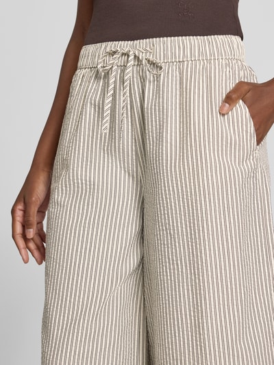 Frauenmodel trägt Regular Fit Culotte aus reiner Baumwolle von s.Oliver RED LABEL, beige mit feinen Streifen, Nahaufnahme Oberkörper.