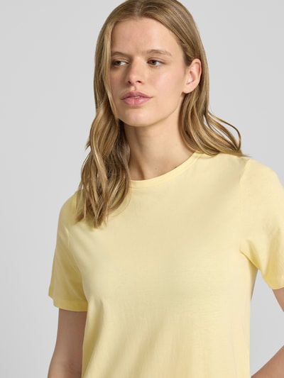 Frauenmodel trägt Regular Fit T-Shirt-Kleid aus reiner Baumwolle Modell 'DISSO' von Pieces in unifarbenem Hellgelb, Nahaufnahme Oberkörper.